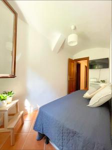 ein Schlafzimmer mit einem blauen Bett in einem Zimmer in der Unterkunft Casa Alleria Venezia in Venedig + 11 Fotos