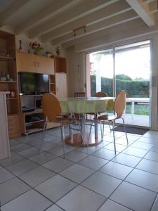 eine Küche mit einem Tisch und Stühlen sowie einem TV in der Unterkunft Biscarrosse Lac Villa 2 chambres et jardin à Navarrosse in Biscarrosse