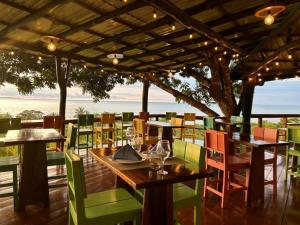 un restaurante con mesas y sillas con el océano en el fondo en Natural Drake Bay Hotel Boutique, en Drake