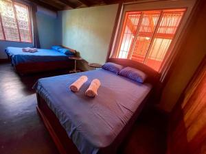 2 Betten in einem Zimmer mit Handtüchern darauf in der Unterkunft Casa Nativo Spring Arenal in Fortuna