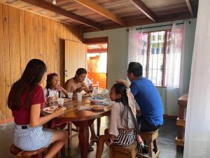 grupa ludzi siedzących przy stole w obiekcie Casa Nativo Spring Arenal w mieście Fortuna