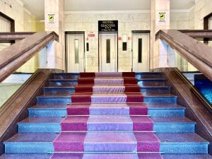 an escalator in a building with colorful stairs at Hotel Giacosa in Milan