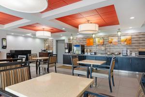 a restaurant with tables and chairs and a bar at Comfort Inn & Suites Carrollton in Carrollton