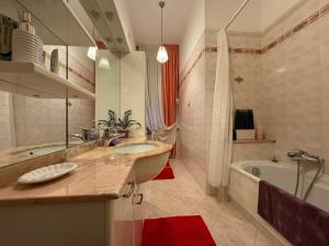 ein Badezimmer mit einem Waschbecken, einer Badewanne und einem Tubermott in der Unterkunft Frontepista in San Giovanni Teatino