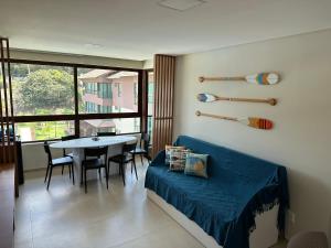 Reserva dos Carneiros 301 في تامانداري: غرفة معيشة مع أريكة زرقاء وطاولة