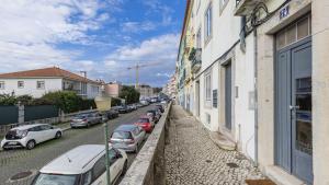 una fila de autos estacionados al lado de una calle en Lisbon Fancy Duplex W/ Patio by LovelyStay, en Lisboa