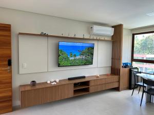 Reserva dos Carneiros 301 في تامانداري: غرفة معيشة مع تلفزيون بشاشة مسطحة على جدار
