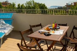 a wooden table and chairs on a balcony at Hotel Altair in Misano Adriatico