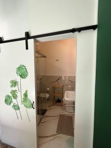 bagno con porta aperta su un bagno con servizi igienici di Harmony Home a Catania