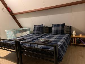 1 dormitorio con 1 cama con manta de cuadros azul en Ferias E55, en Lanaken