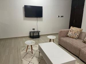 A television and/or entertainment centre at Bright & Beautiful 2-Bed Apartment, Central Kumasi