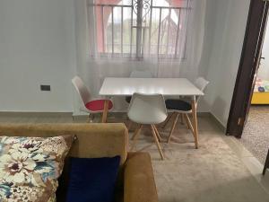 a living room with a white table and chairs at Bright & Beautiful 2-Bed Apartment, Central Kumasi in Kumasi