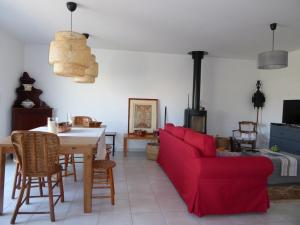 ein Wohnzimmer mit einem roten Sofa und einem Tisch in der Unterkunft Sanguinet Jolie maison mitoyenne pour 6 pers in Sanguinet