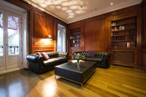 a living room with leather furniture and a table at Hospes Puerta de Alcalá, a Member of Design Hotels in Madrid