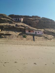 ein Haus an der Seite eines felsigen Hügels in der Unterkunft Cave's on to the beach in Douaïra