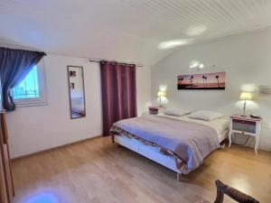 um quarto com uma cama e duas mesas e dois candeeiros em Villa avec piscine à 10 min des plages. em Vendres