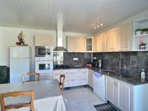 a kitchen with white appliances and a table in it at Lest in Vendres