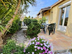 a patio with a table and chairs and flowers at Lest in Vendres