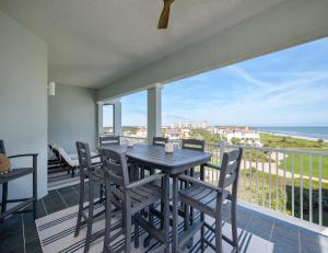 a table and chairs on a balcony with a view of the ocean at 365 Cinnamon Beach in Palm Coast