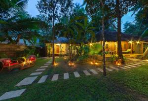 un patio trasero con una casa con luces en el césped en Marari Villas - Private Pool Villas, en Mararikulam