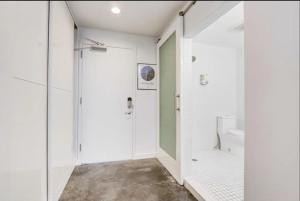 a white bathroom with a shower and a toilet at KCM Tremont Oaks Apartments 5 in Cleveland