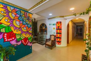 un couloir orné d'une peinture colorée sur le mur. dans l'établissement Hotel Real Guatapé, à Guatapé