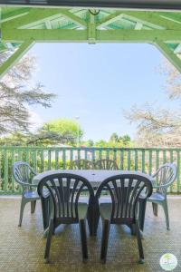 - une table et deux chaises sur la terrasse dans l'établissement Sanguinet Appartement 3 chambres proche du lac, à Sanguinet