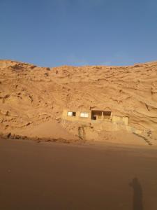 Ein Schatten einer Person, die in der Wüste steht in der Unterkunft Cave's on to the beach in Douaïra