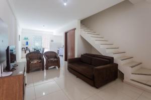 a living room with a couch and a staircase at Sobrado a 300m da praia de Ilhéus VCM005 in Ilhéus