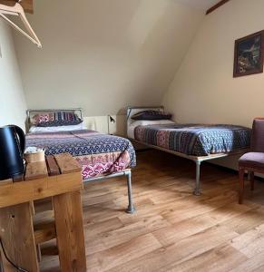 a room with two beds and a table and a chair at Anglesey Outdoors in Holyhead