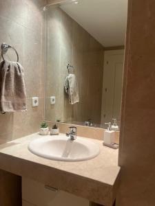 ein Badezimmer mit einem Waschbecken und einem großen Spiegel in der Unterkunft Walking distance to Puerto Banus sea view Apartment in Marbella