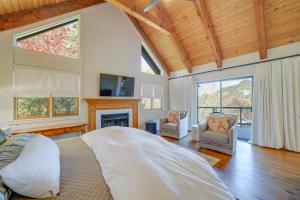 a bedroom with a bed and two chairs and a fireplace at Stunning Cashiers Vacation Home with Mountain Views! in Cashiers