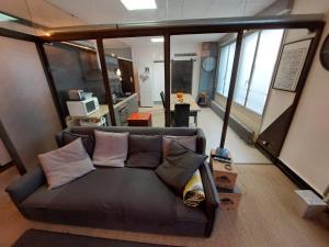 - un salon avec un canapé et des oreillers dans l'établissement Loft Partagé Agréable et spacieux, à Aire-sur-lʼAdour
