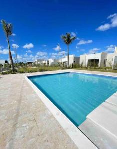 uma piscina azul com palmeiras ao fundo em Downtown Punta Cana Villa em Punta Cana