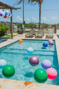 a pool with colorful balls in the water at The Coral Beach Resort by Atlantica in Trairi