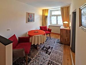 a living room with a table and red chairs at ADORIS FERIENWOHNUNGEN auf der Lindauer Insel in Lindau