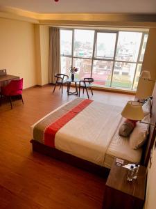 una habitación de hotel con una cama grande y una mesa en SM HOTEL Plus en Lima