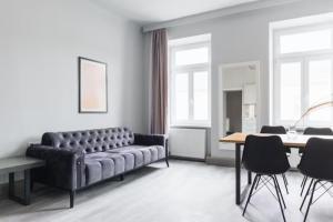 een woonkamer met een bank en een tafel bij Malfatti Urban Oasis in Wenen