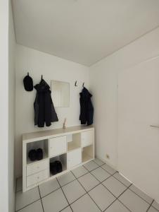 a room with white cabinets and black shirts on hooks at Ferienwohnung nähe Montabaur A3 