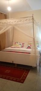 un letto bianco a baldacchino in una stanza di TRANGQUIL APARTMENTS a Kitengela 