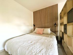 - une chambre avec un lit blanc et un mur dans l'établissement Casa JONA, à Cagnes-sur-Mer