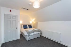 Un dormitorio con una cama con almohadas azules. en Cherry Property - Blueberry Suite, en Blackpool