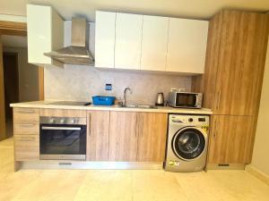 a kitchen with a washing machine and a microwave at Fabulous Sea view 1 BR & private Garden to the pool at Mangroovy in Hurghada