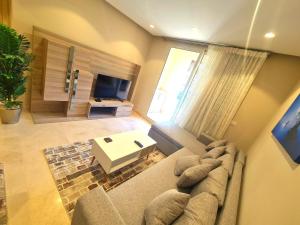 ein Wohnzimmer mit einem Sofa und einem TV in der Unterkunft Fabulous Sea view 1 BR & private Garden to the pool at Mangroovy in Hurghada