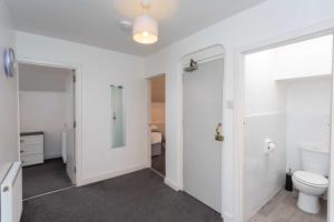 a bathroom with a toilet and a glass door at Cherry Property - Blueberry Suite in Blackpool