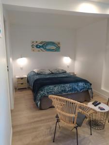 1 dormitorio con 1 cama y 1 silla en CAP MANVIEUX Gîtes en Manvieux