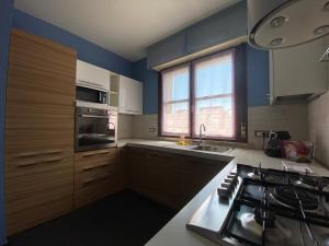 a kitchen with blue walls and a sink and a stove at Chicco Apartment Small Business in Vercelli