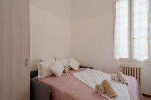 a bedroom with a bed with a pink blanket and pillows at Appartamento Centrale - sulla pedonale in Dolceacqua