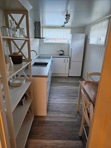 uma pequena cozinha com um frigorífico e uma mesa em Cozy home em Gravdal