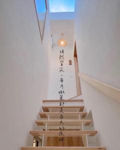 un conjunto de escaleras con escritura asiática en la pared en 沐正農場 嘉義包棟民宿 en Zhongpu